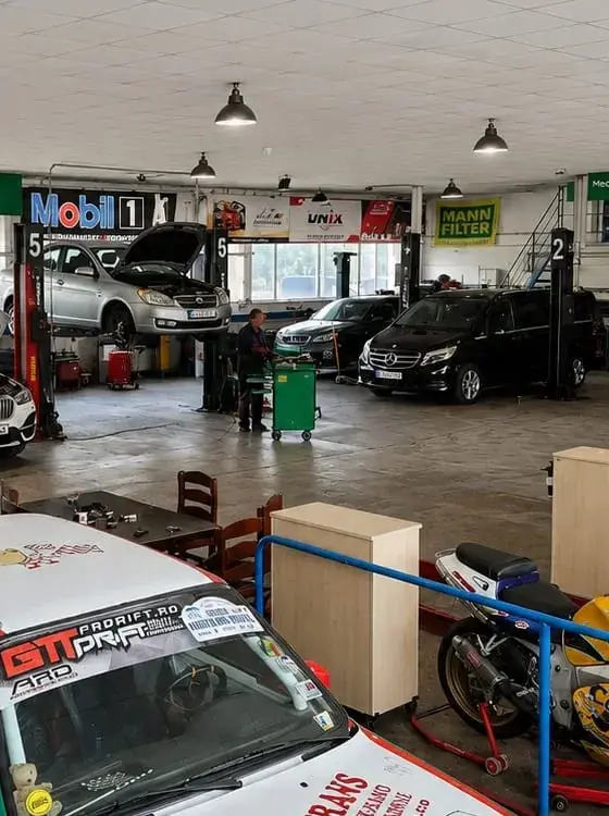 Hala LMC Service Auto din Voinești: mașini pe elevatoare în posturile de lucru